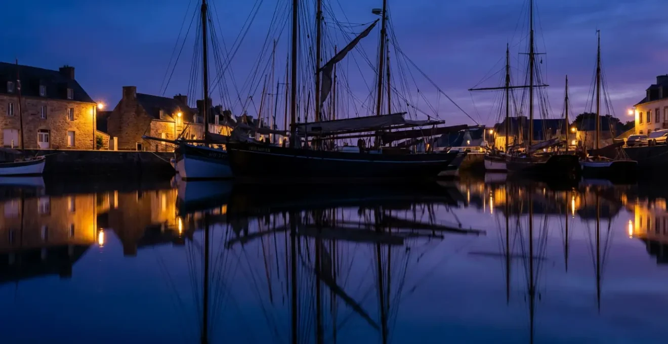 Vue des bateaux historiques amarrés au Port-Rhu de Douarnenez avec leurs mâts se reflétant dans l'eau calme