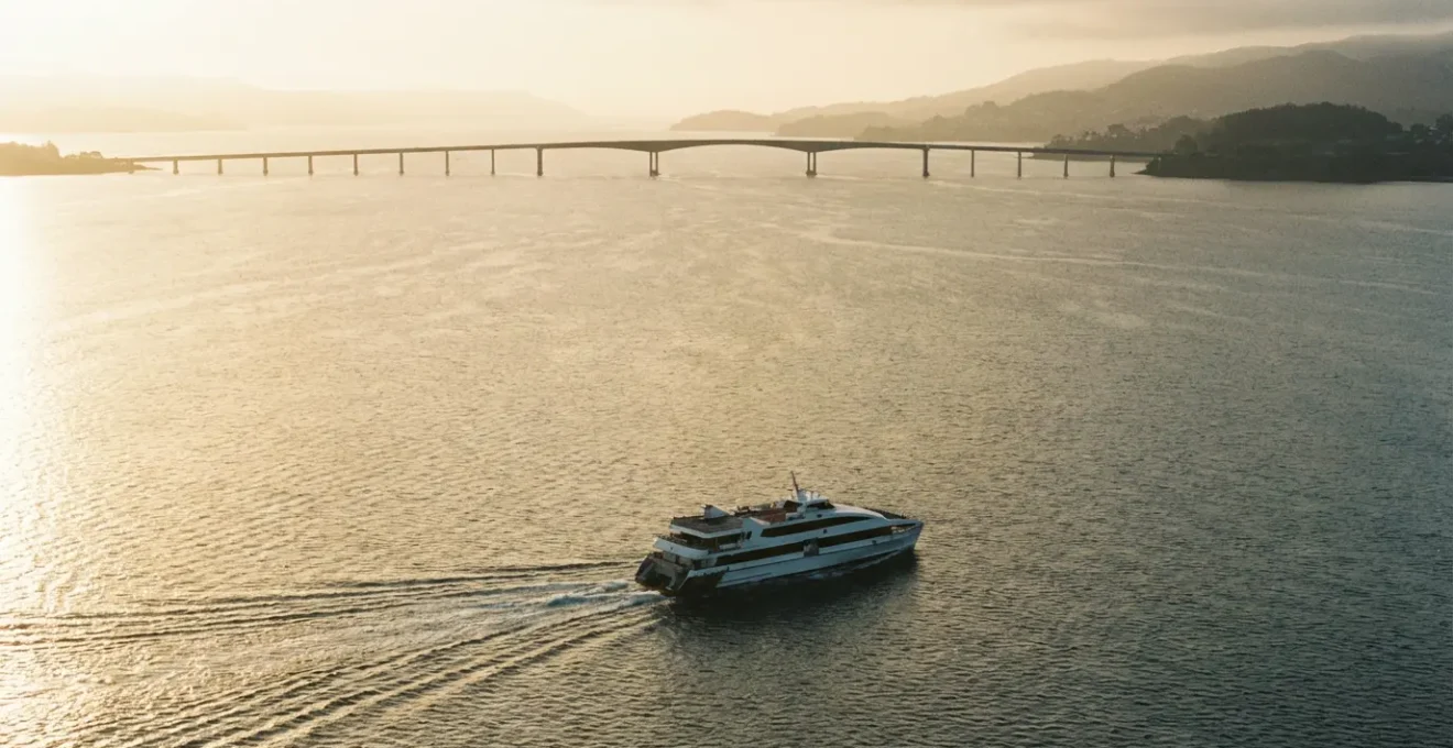 Vue panoramique d'un bateau navette traversant la rade de Brest avec le pont de l'Iroise visible au loin