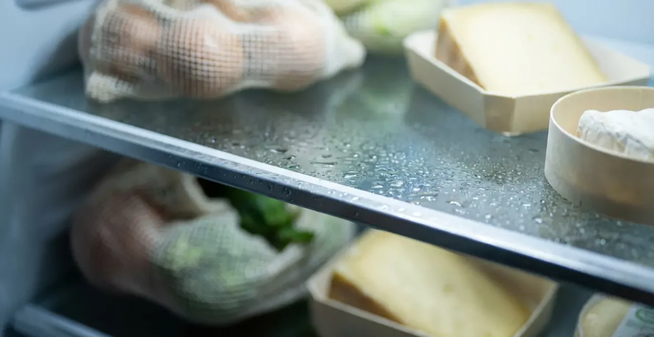 Vue macro de l'intérieur d'un petit frigo de mobil-home parfaitement organisé avec système de zones