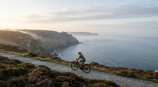 Cycliste en vélo électrique gravissant une côte escarpée sur la presqu'île de Crozon face à l'océan